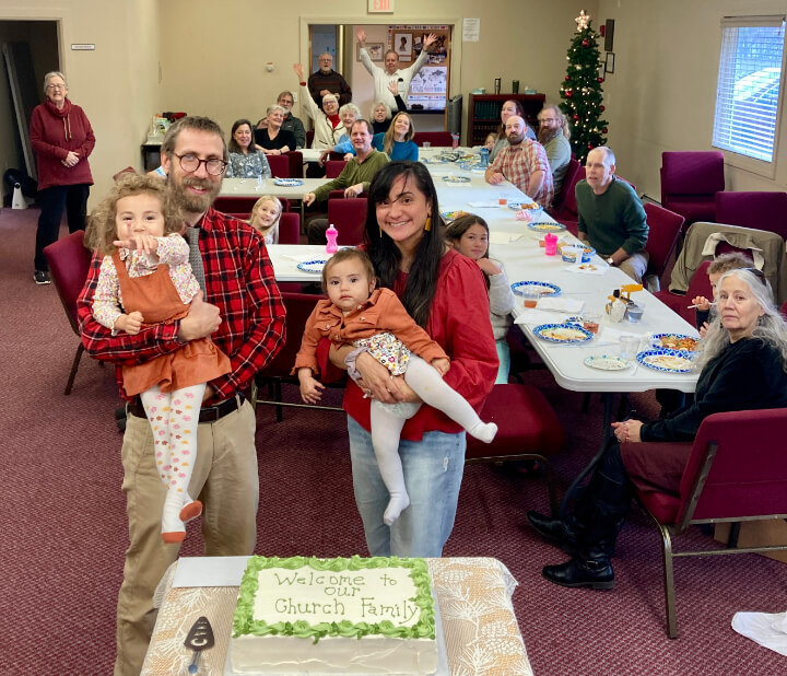 Pastor and his family gathered with congregation members at their welcome party